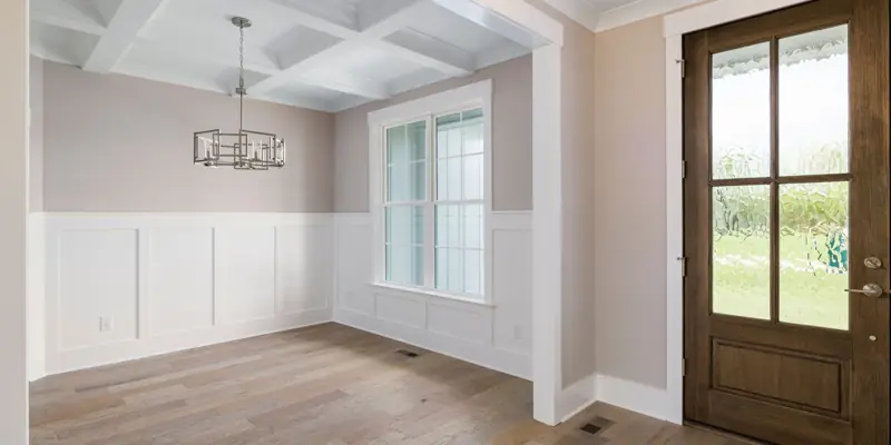A room with new baseboard, wainscot and door trim