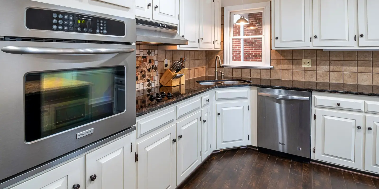 A kitchen with white painted cabinets