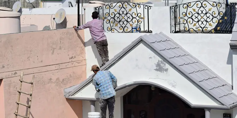 Painters working on the outside of a house
