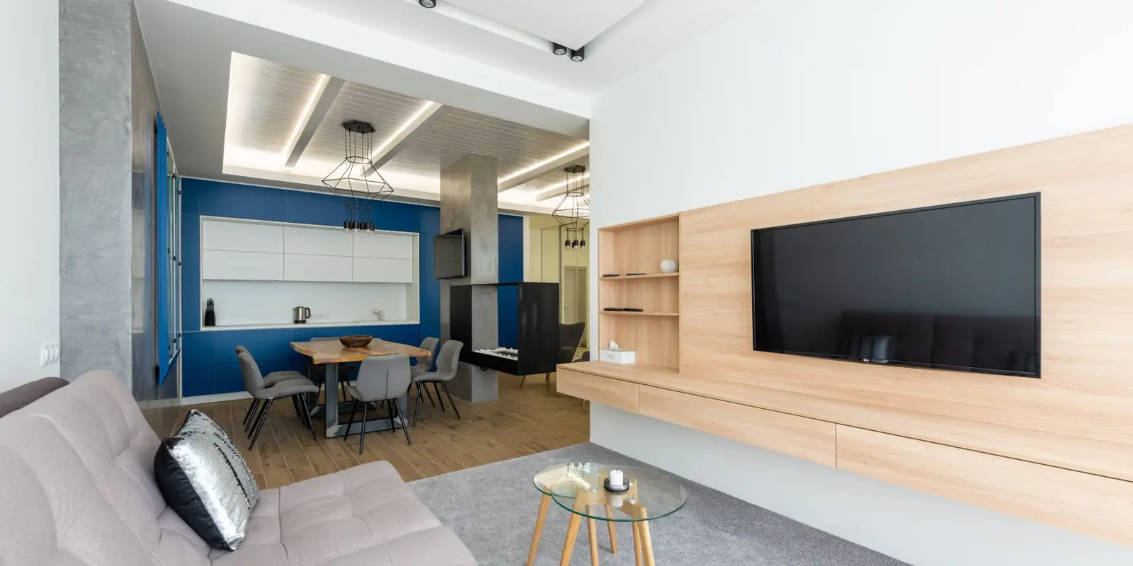 A living room with a wall-mounted TV and no cords showing