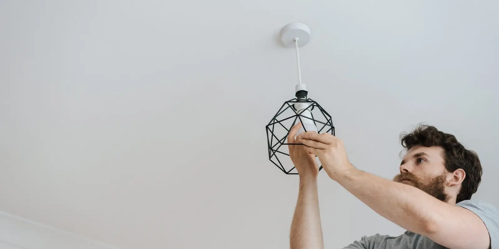 A man putting up a ceiling light