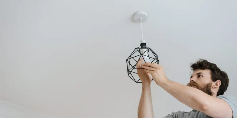 A man putting up a ceiling light