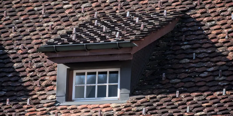 A shingle roof with a dormer window