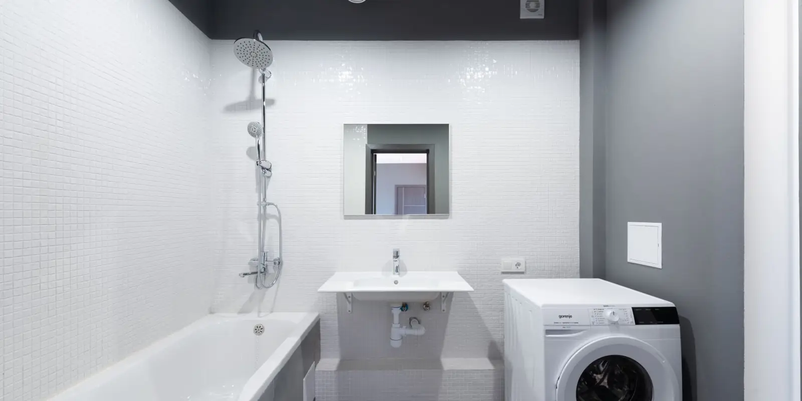 A washing machine set up beside a tub